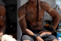 Young Black Guy With Upper Body And Arm Tattoos Sitting On Bar Stock throughout size 865 X 1390