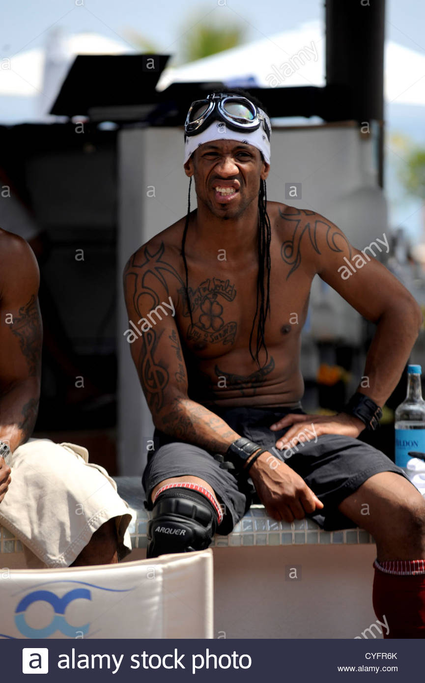 Young Black Guy With Upper Body And Arm Tattoos Sitting On Bar Stock throughout size 865 X 1390